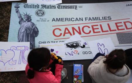 photo of a canceled US Treasury check to american families with two children drawing in the foreground