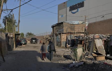 photo of a slum with the amazon building in the background