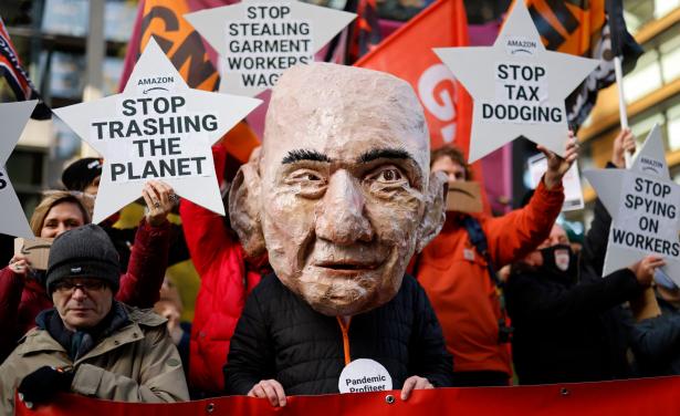 Protesters with signs against Amazon.  Besos puppet in the forground 