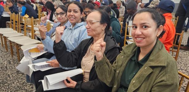 Photo of a group of women seated with raised fists.