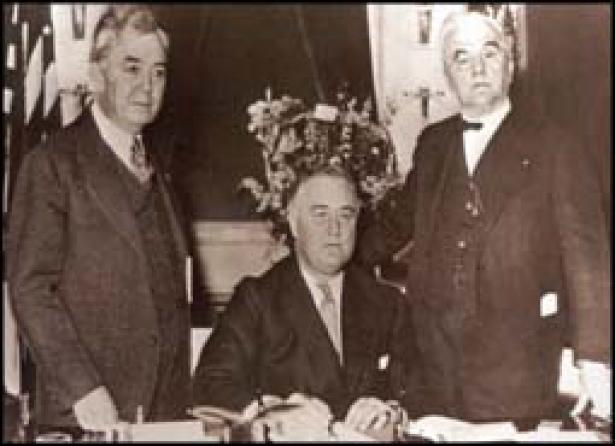 On May 20, 1936 Franklin Delano Roosevelt (center) signs the Rural Electrification Act. 