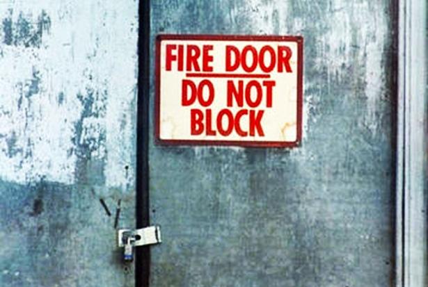 A padlocked door marked "FIRE DOOR: DO NOT BLOCK" 