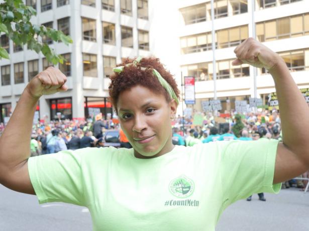 Female construction worker with raise fists in the street.   