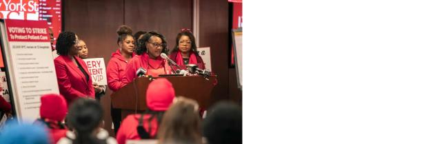 Woman (NYSNA President) at a podium flanked by Nurses in red.