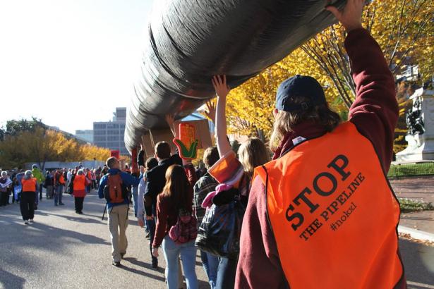 Keystone XL protesters carry a replica pipeline. 