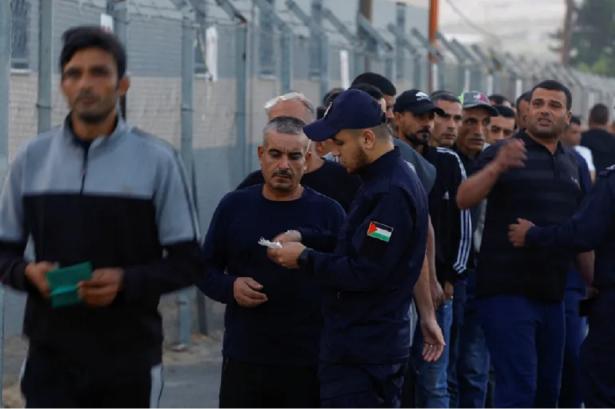 photo of a group of workers lined up and showing a policeman documentsne