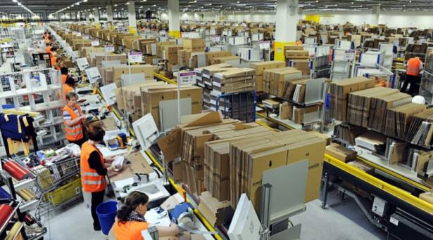 Photo of the inside of a warehouse with workers on the job.