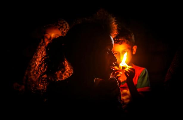 Palestinian children sitting in the dark due to power outage