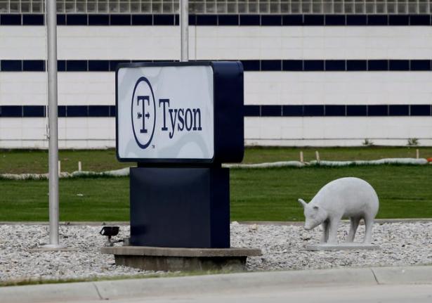 Tyson signage outside of packing plant alongside a ceramic pig. 