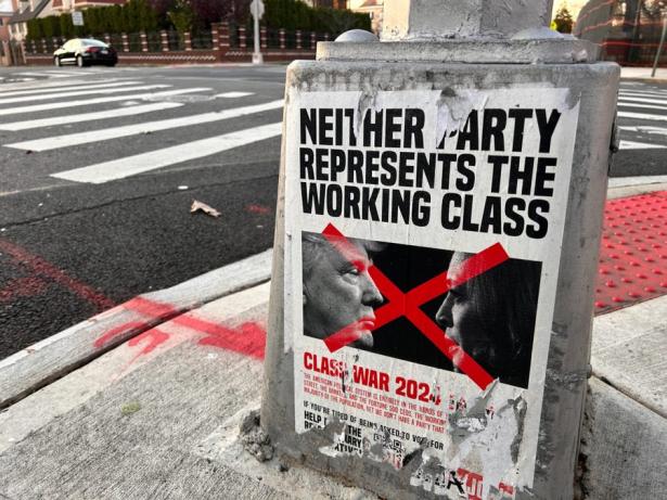 photo of a weather-worn and tattered poster on the street that says Neither Party Represents the Working Class.