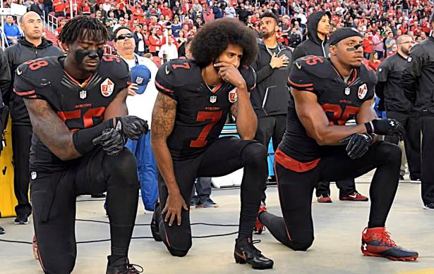 Colin Kaepernick and two teammates taking a knee before a 49ers game