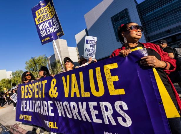 Photo of workers rallying holding a sign that says: Respect & Value Healthcare Workers