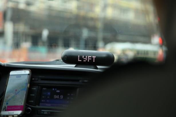 photo from inside a car with a sign LYFT atop the dash board 