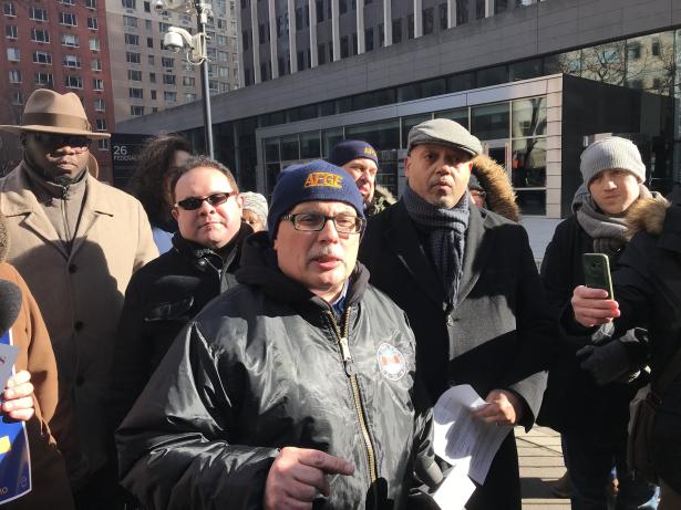 several government workers rallying outside a government office.