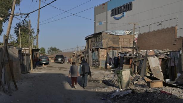 photo of a slum with the amazon building in the background