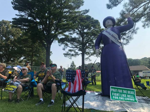 Strikers sitting next to a blow up of Mother Jones