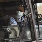 Bus Driver driving seen through the windshield wearing a mask.