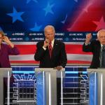 Three candidates at podiums at DNC primary debate 
