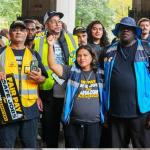 Photo of workers with signs reading "fair pay safe jobs"
