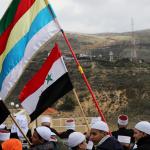 Members of Syria’s Druze community hold Syrian and Druze flags. 