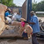 Workers throw away debris and ruined possessions from a public housing project in Texas.
