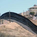 intimidating border wall with barbed wire covering