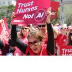Photo of Nurses in red scrubs rallying .