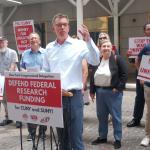 President of PSC and other members rally with signs saying "stop the war of universities". th