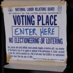 A union voting place sign is taped to the entrance of a Starbucks that reads:  NLRB Voting Place Enter Here.