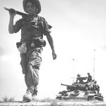 French soldier on foot in Vietnam in front of a U.S.-supplied tank