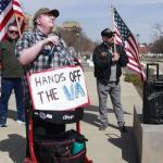 Photo of people marching with signs like, "Hands off the VA".
