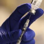 A pharmacist fills a syringe to prepare a dose of vaccine for front-line health care workers in Torrance, CA. 