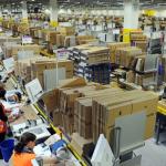 Photo of the inside of a warehouse with workers on the job.