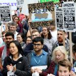 Photo of many people at a protest with signs.