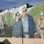 Photo of a painted mural of three coal miners.