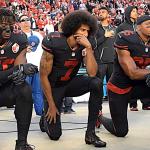 Colin Kaepernick and two teammates taking a knee before a 49ers game