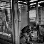 unhoused man at bus stop