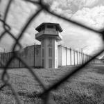 prison with guardtower and barbed wire fence