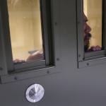 prisoner loooking out of prison door window