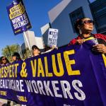 Photo of workers rallying holding a sign that says: Respect & Value Healthcare Workers