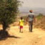 adult and child walking on a dirt path