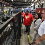 labor secretary and a couple of workers looking over a factory.