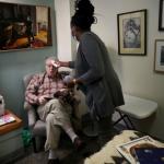nursing aide helping older man