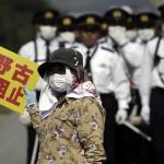 demonstrator in Okinawa surrounded by police