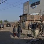 photo of a slum with the amazon building in the background