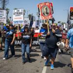Photo at the front of a march going forward with signs reading Teamsters against fascism.