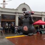 Photo of workers with signs and rat outside starbucks store 