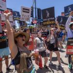 photo of strikers holding on strike signs from SAG-AFTRA and WGAstrike signs ing 