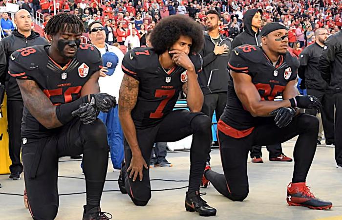 Colin Kaepernick and two teammates taking a knee before a 49ers game