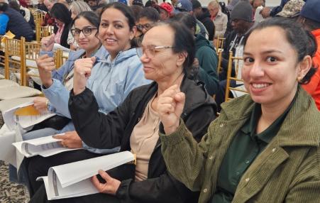 Photo of a group of women seated with raised fists.